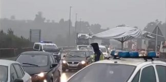 Policías nacionales frontera tuy con sombrillas de playa para protegerse del temporal de viento y lluvia
